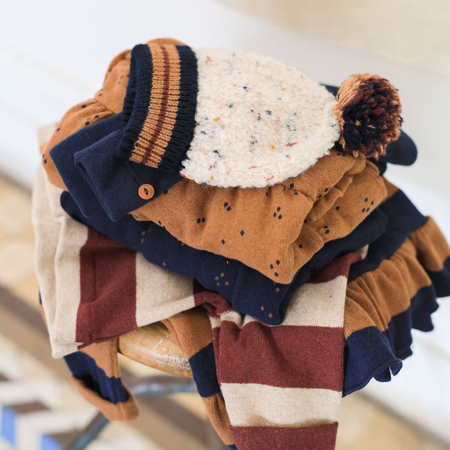 Stack of colorful children's hats on a chair