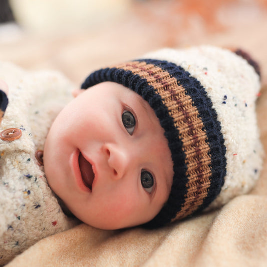 Newborn baby wearing a striped hat with a blurred background
