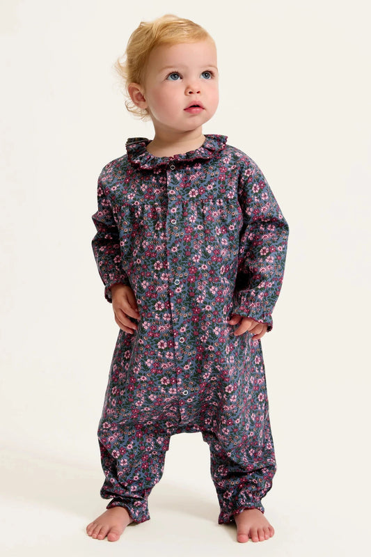 Child wearing a floral onesie on a white background