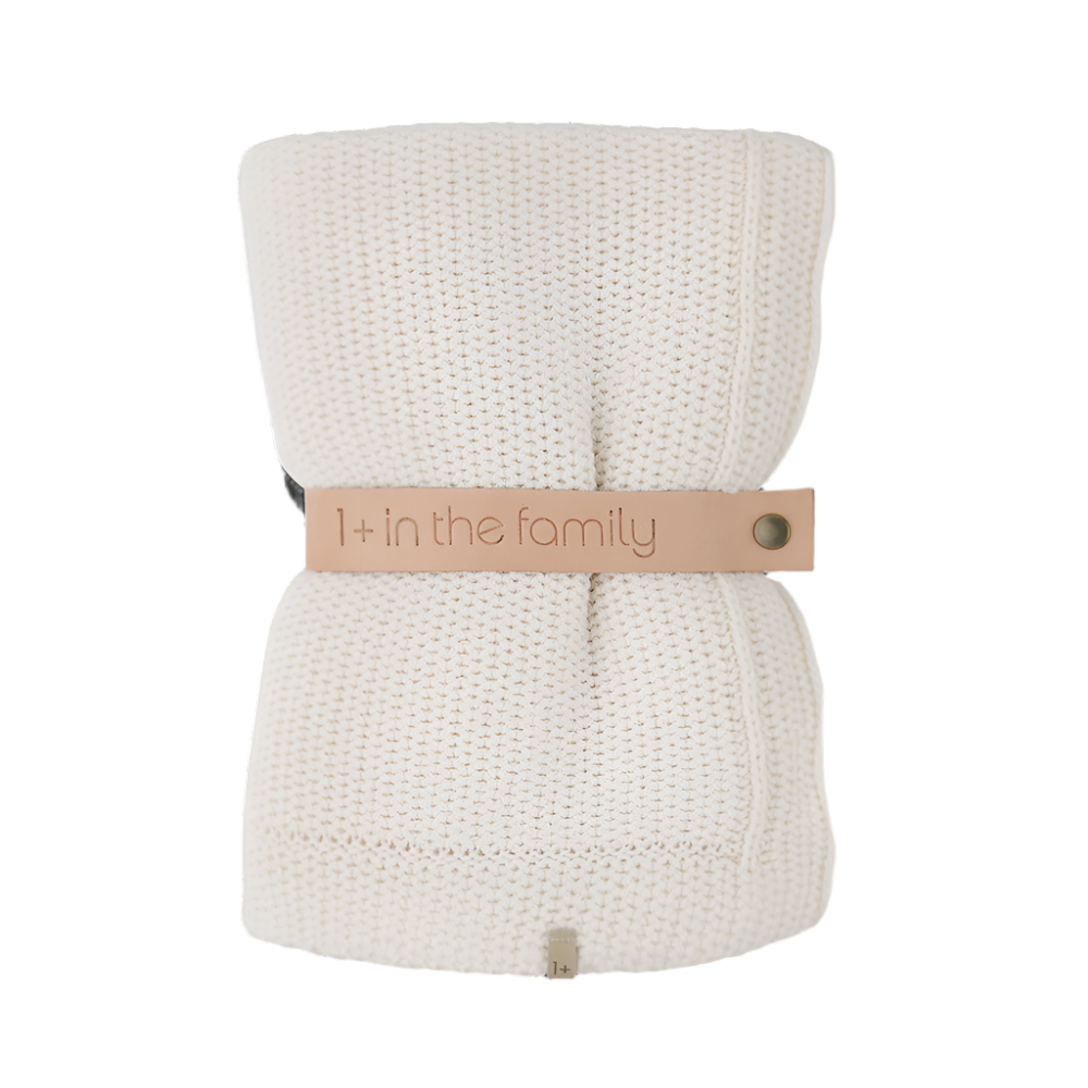 Ecru wool knitted blanket with '1+ in the family' label