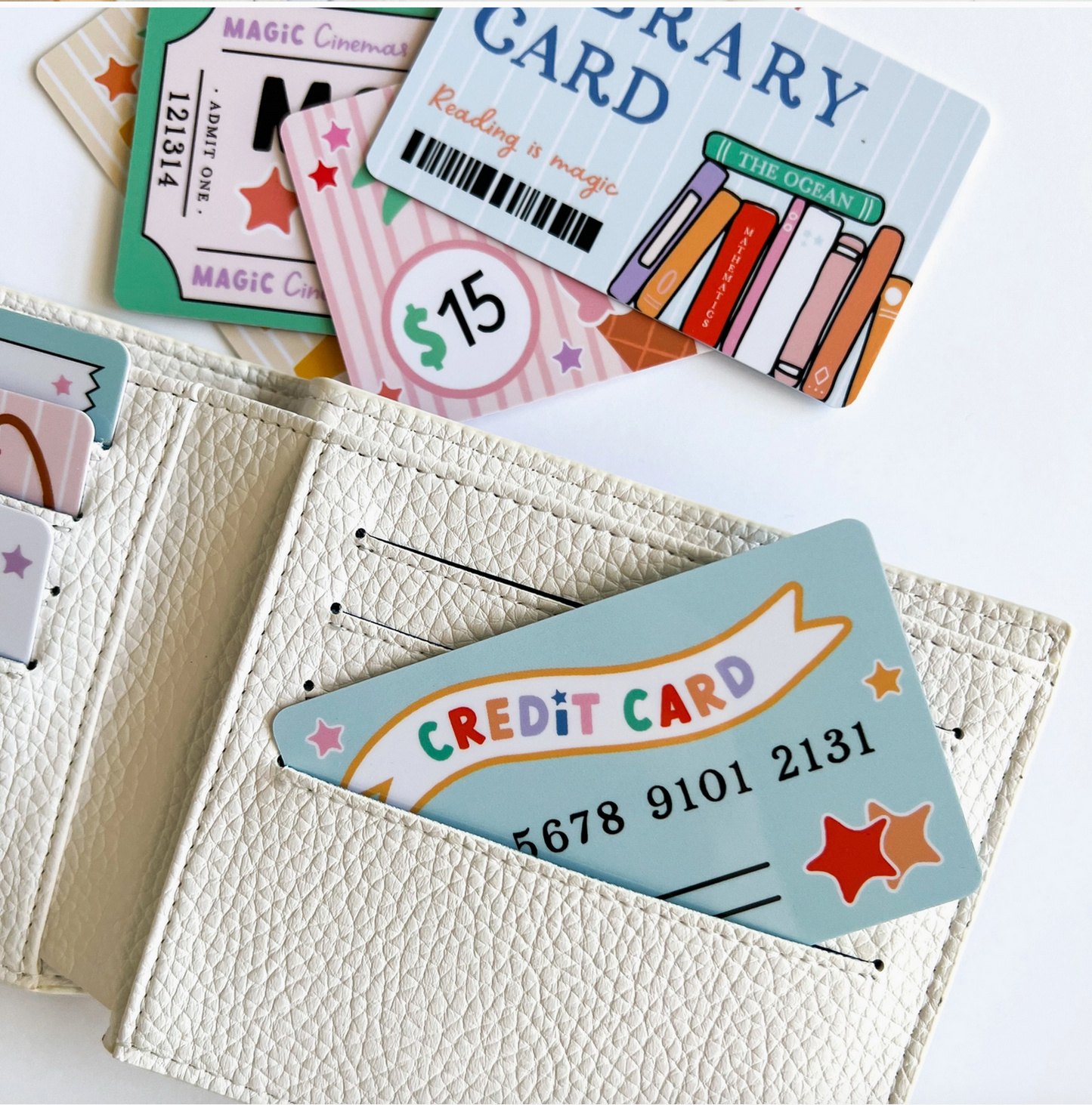 Collection of various cards including a library card and a credit card, with a white wallet holding a credit card.