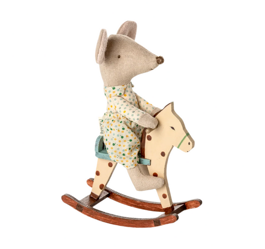 Toy mouse in pajamas riding a wooden rocking horse on a light beige background