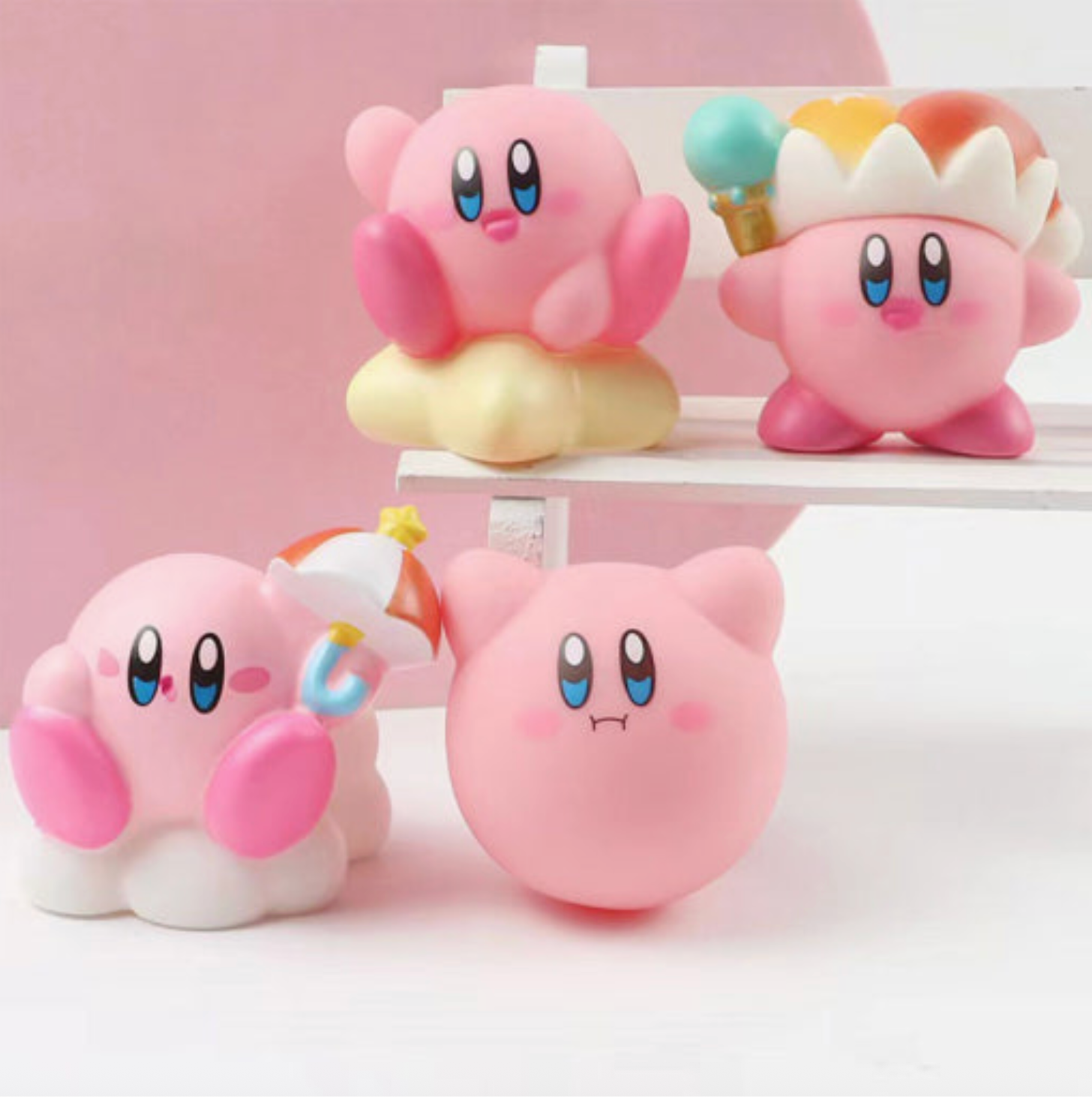 Four pink cartoon characters with blue eyes and colorful hats on a white stand against a pink background. - Little-ish