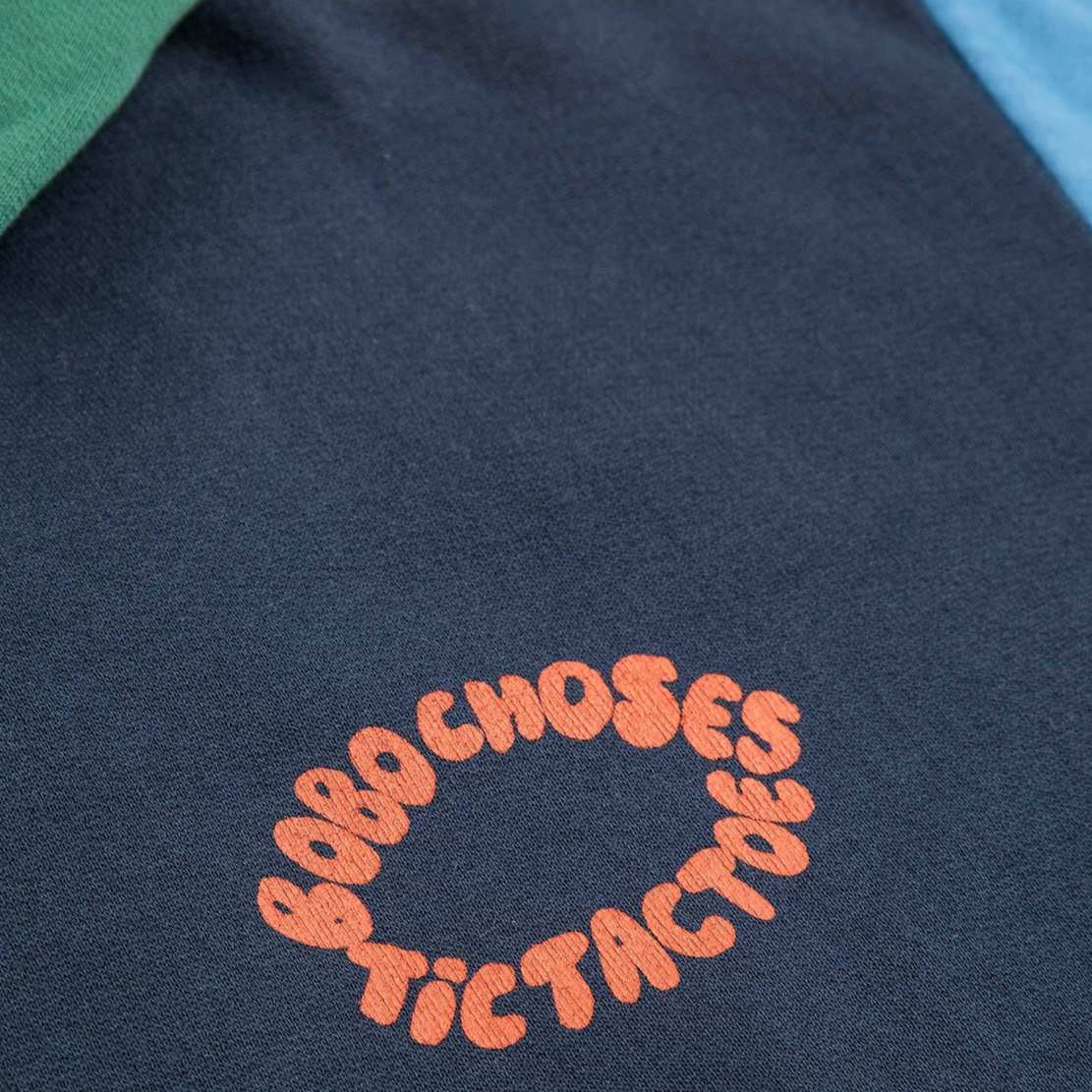 Navy blue garment with orange text embroidery on a dark background