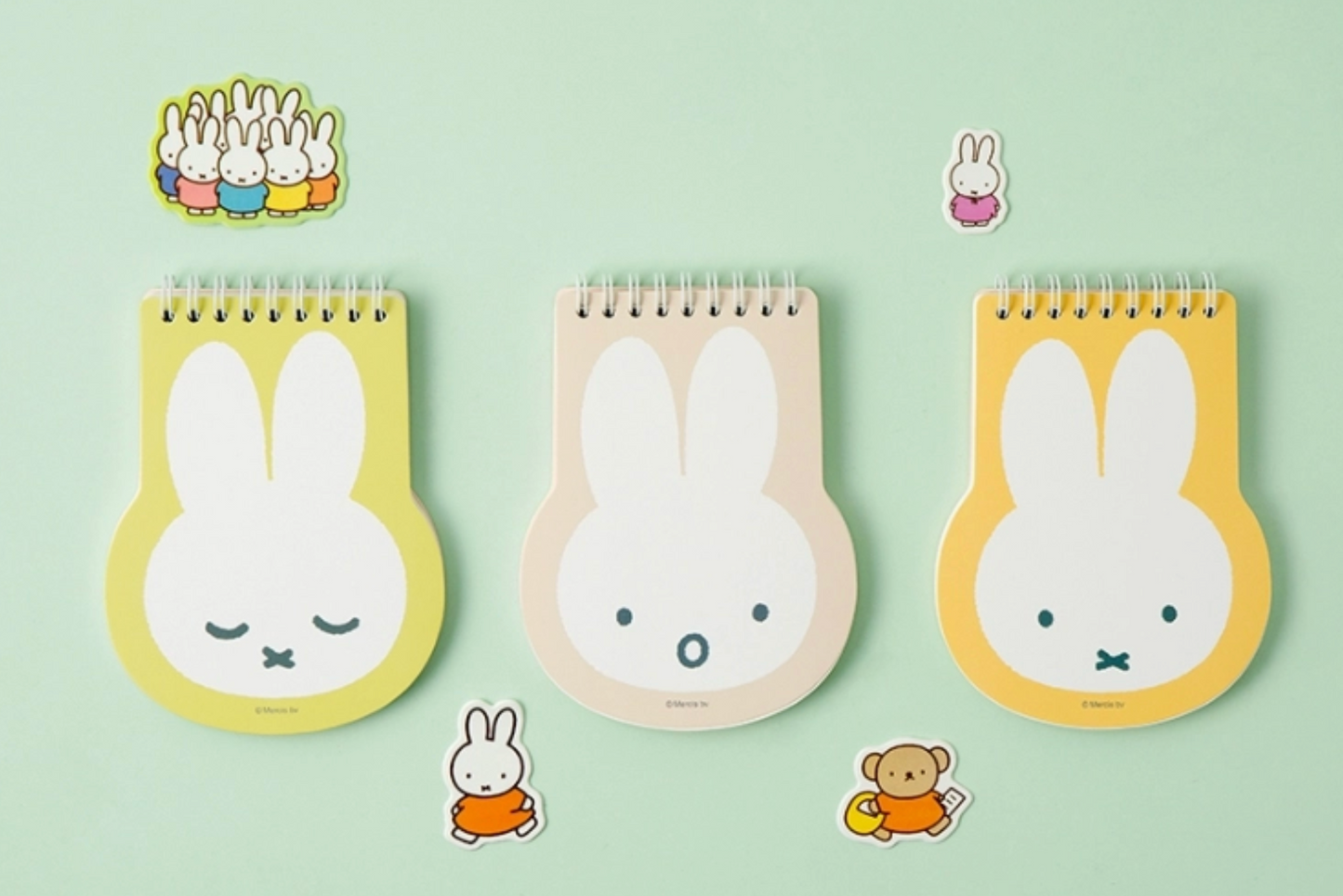 Three rabbit-shaped notepads with small illustrations on a green background