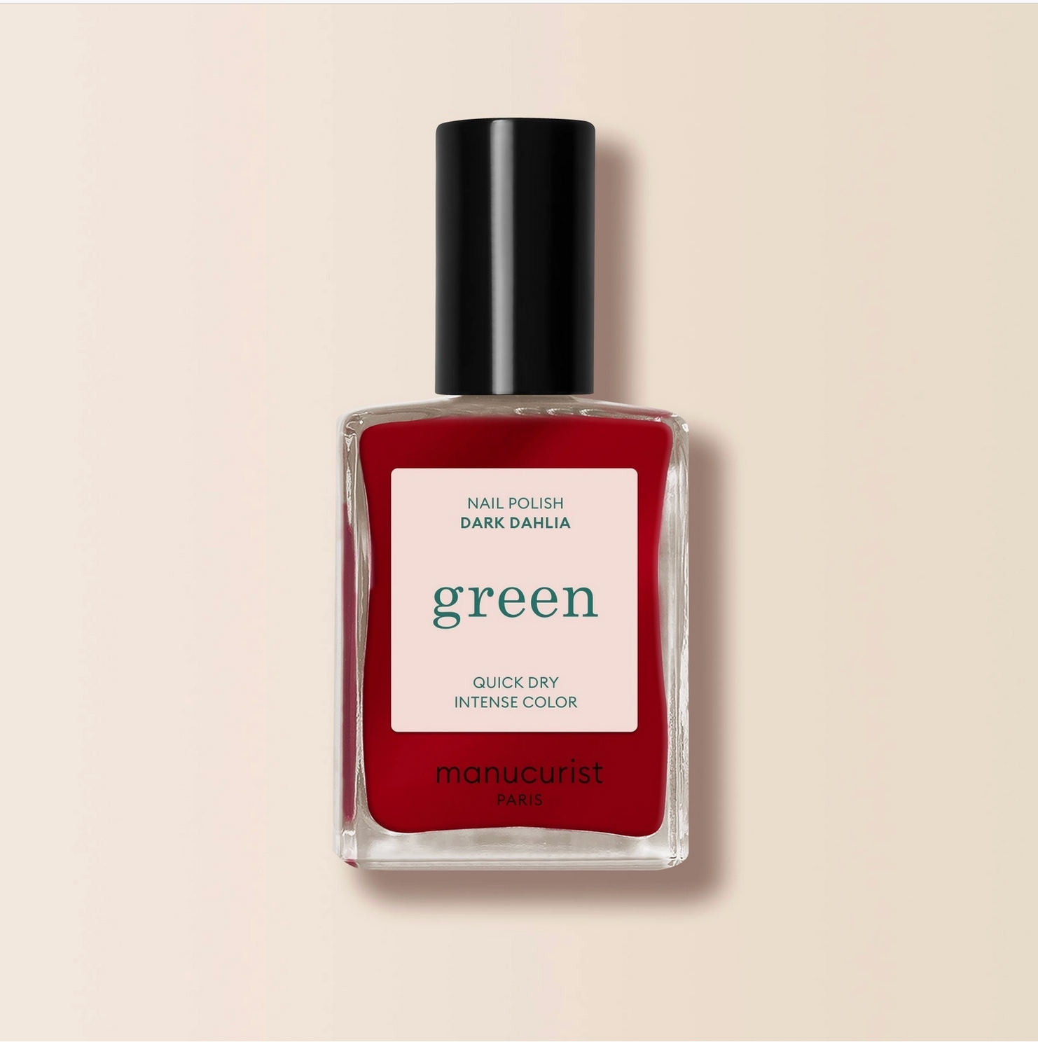 Red nail polish bottle with a black cap on a beige background - Little-ish