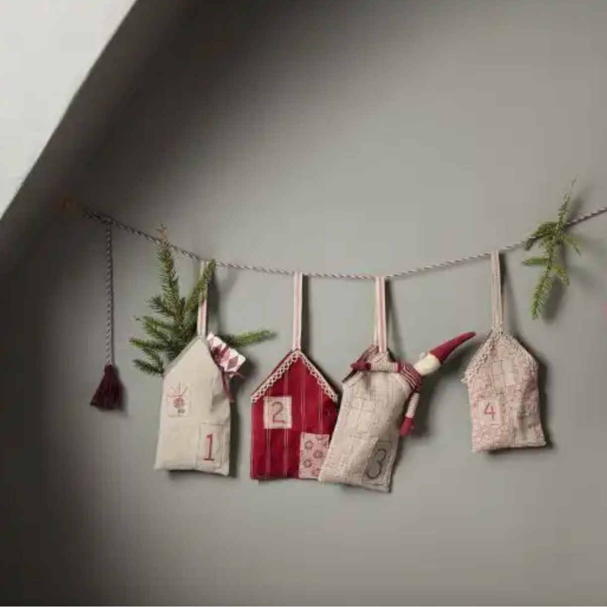 Decorative advent calendar with small houses and numbers on a gray wall. - Little-ish