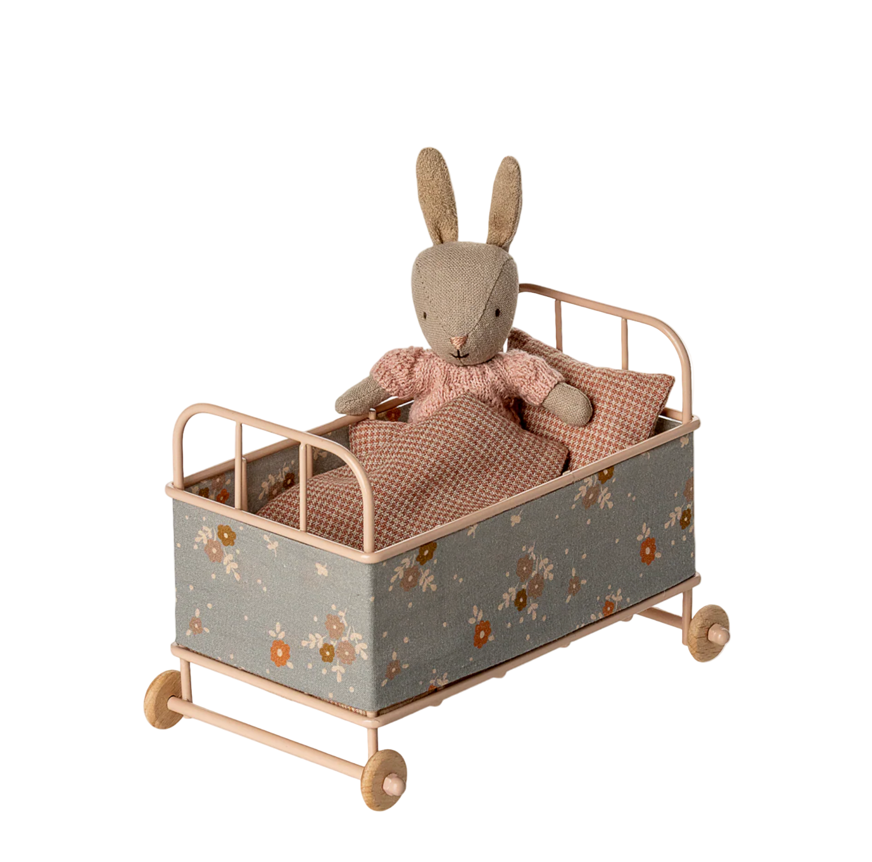 Toy rabbit in a small bed with floral pattern on a white background - Little-ish