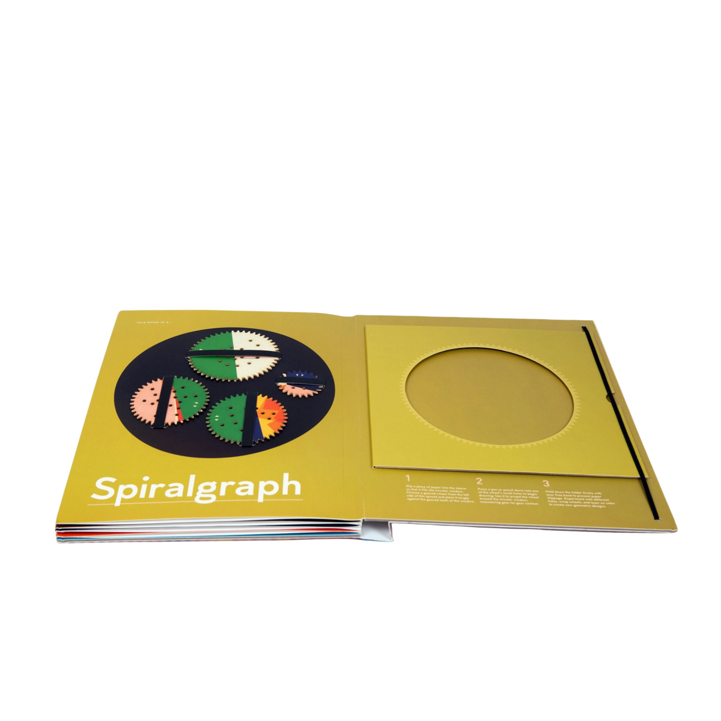 Spiralgraph book open on a white surface with a computer screen in the background