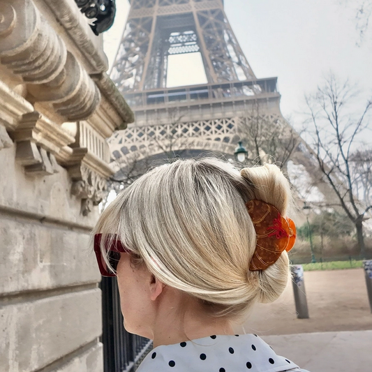 Person with styled hair in front of the Eiffel Tower