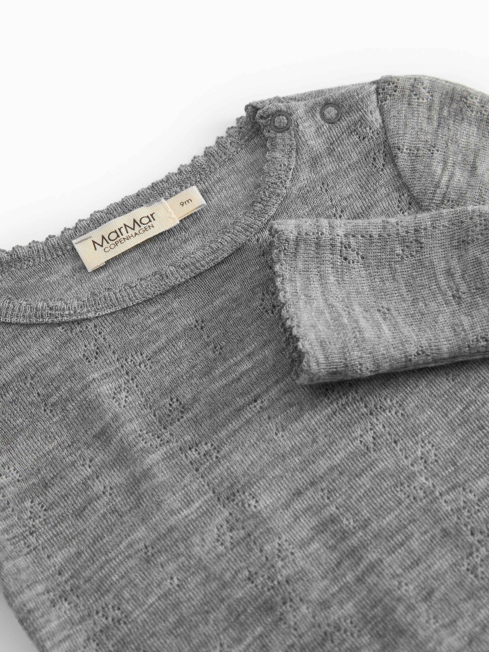 Gray textured fabric with a brand label on a white background - Little-ish