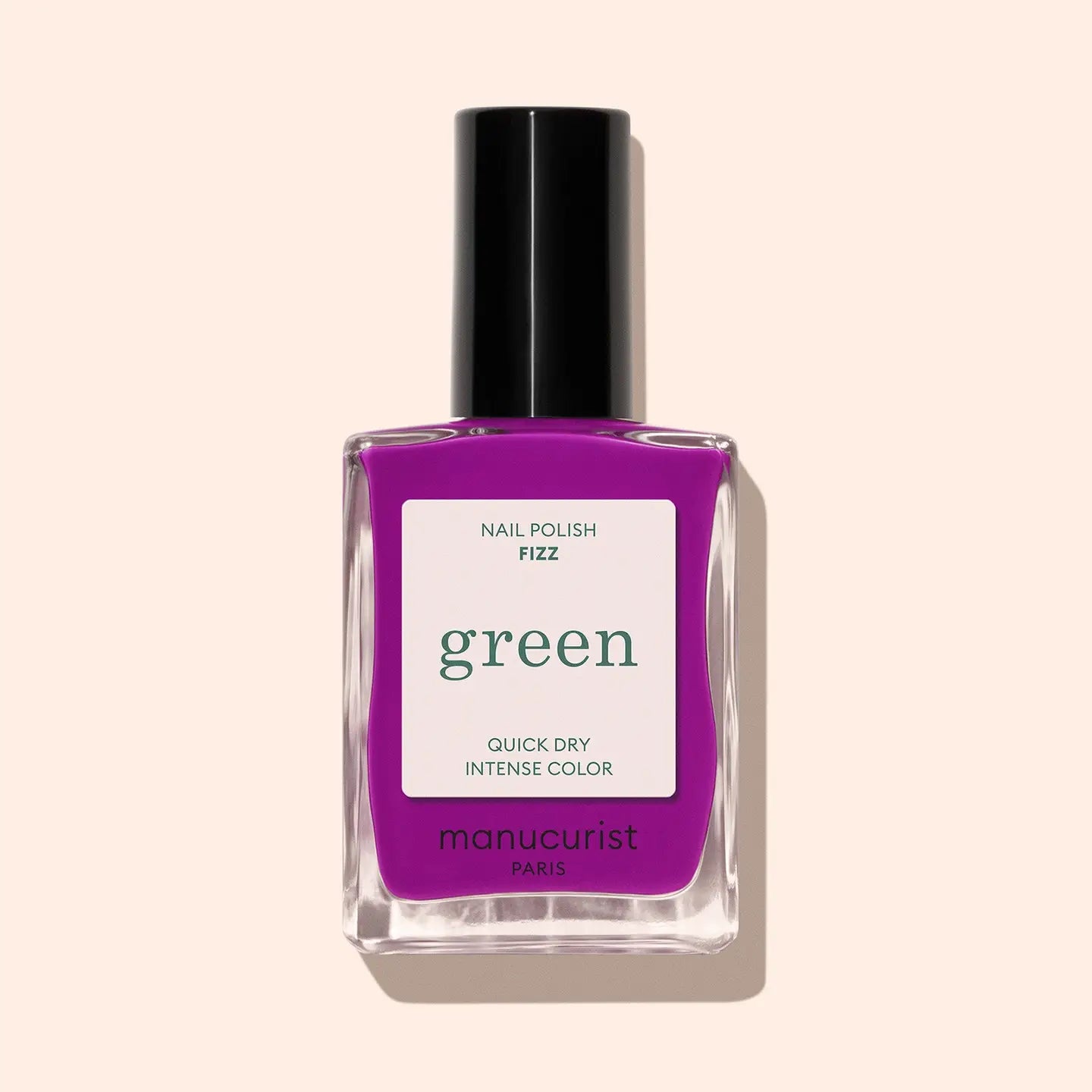Purple nail polish bottle with 'green' label on a beige background