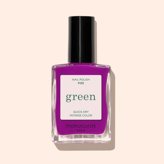 Purple nail polish bottle with 'green' label on a beige background