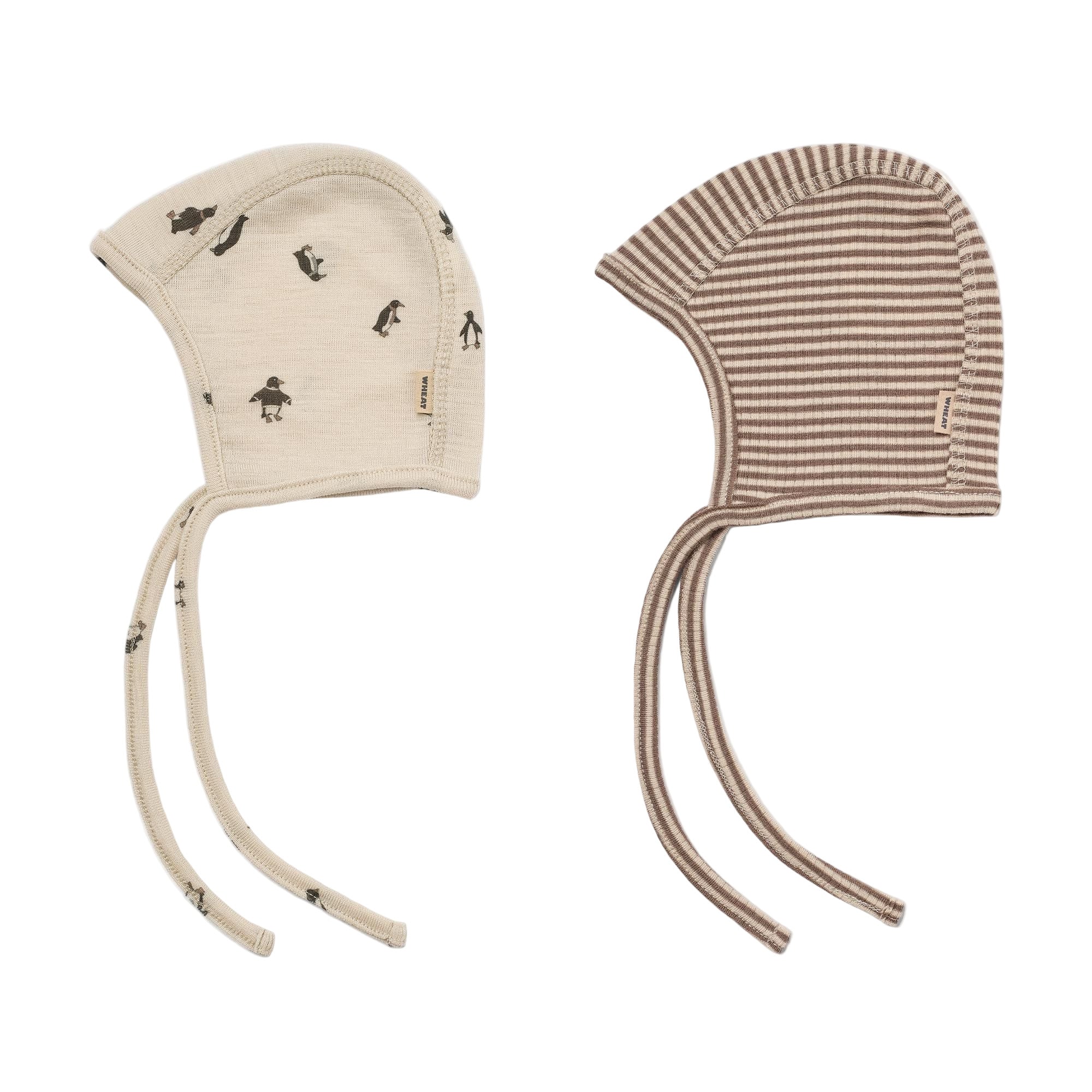 Two baby hats on a white background, one with penguin pattern and the other striped. - Little-ish