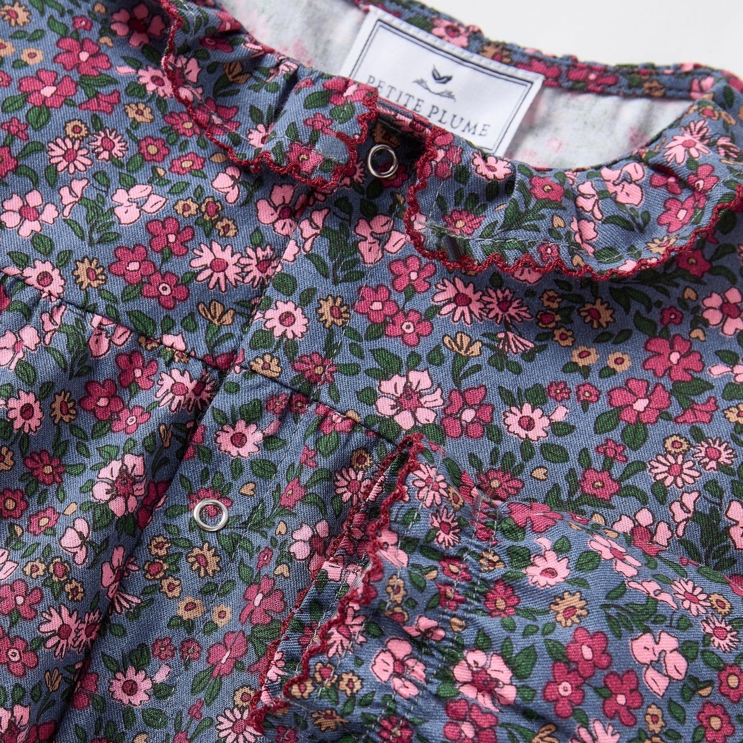 Floral patterned fabric with a brand label in the background