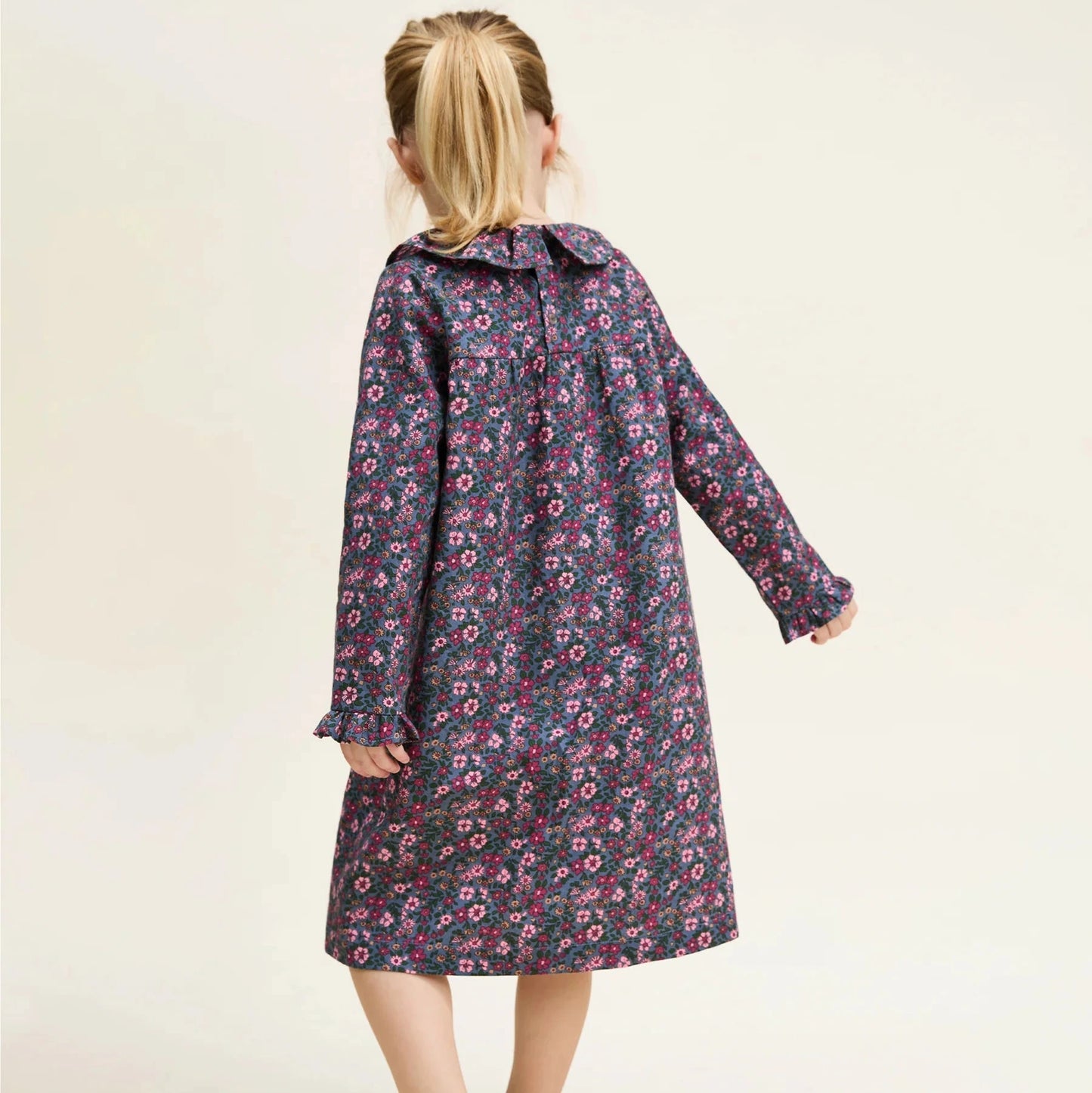 Girl wearing a floral dress against a plain background