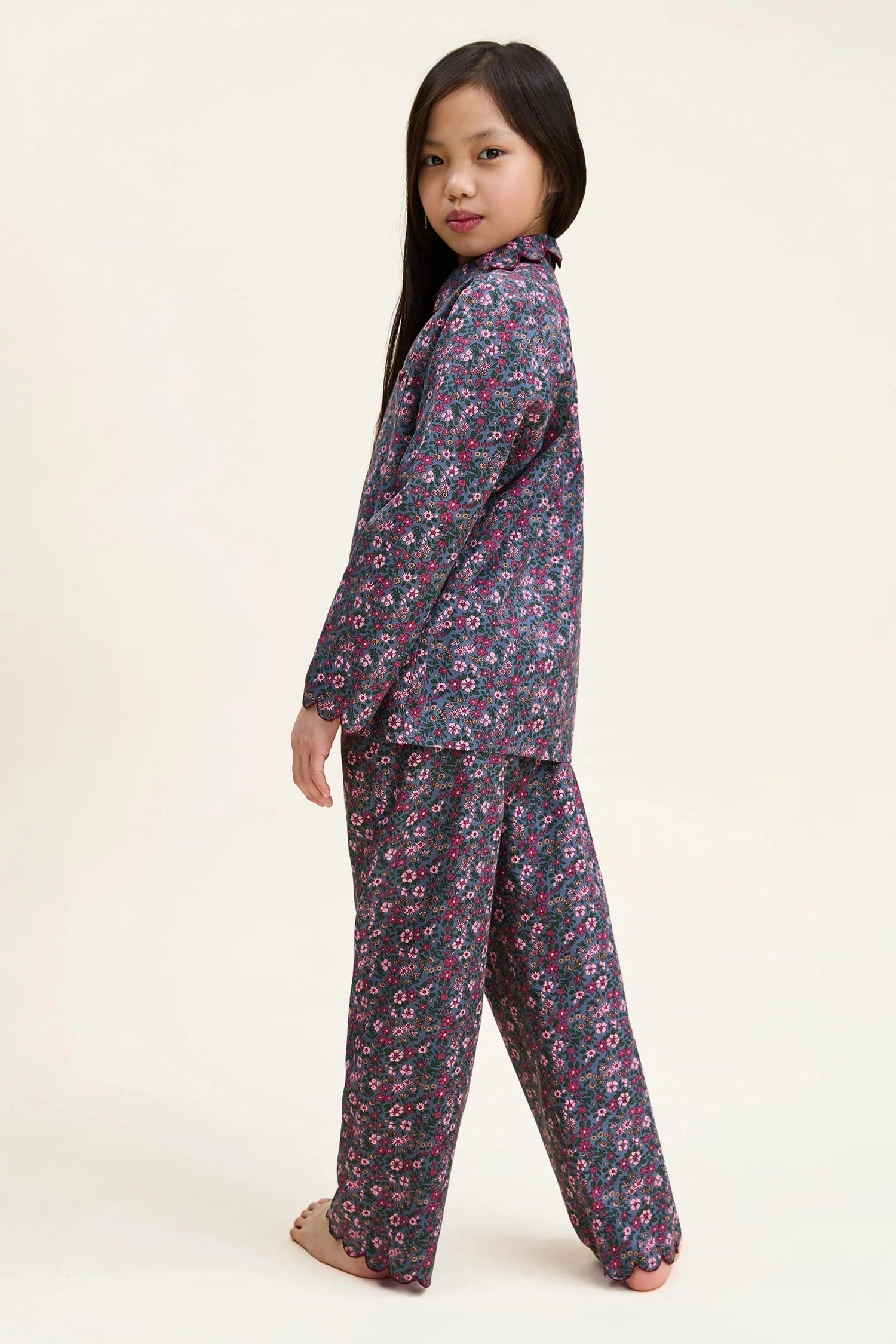 Young girl wearing a floral pajama set on a white background