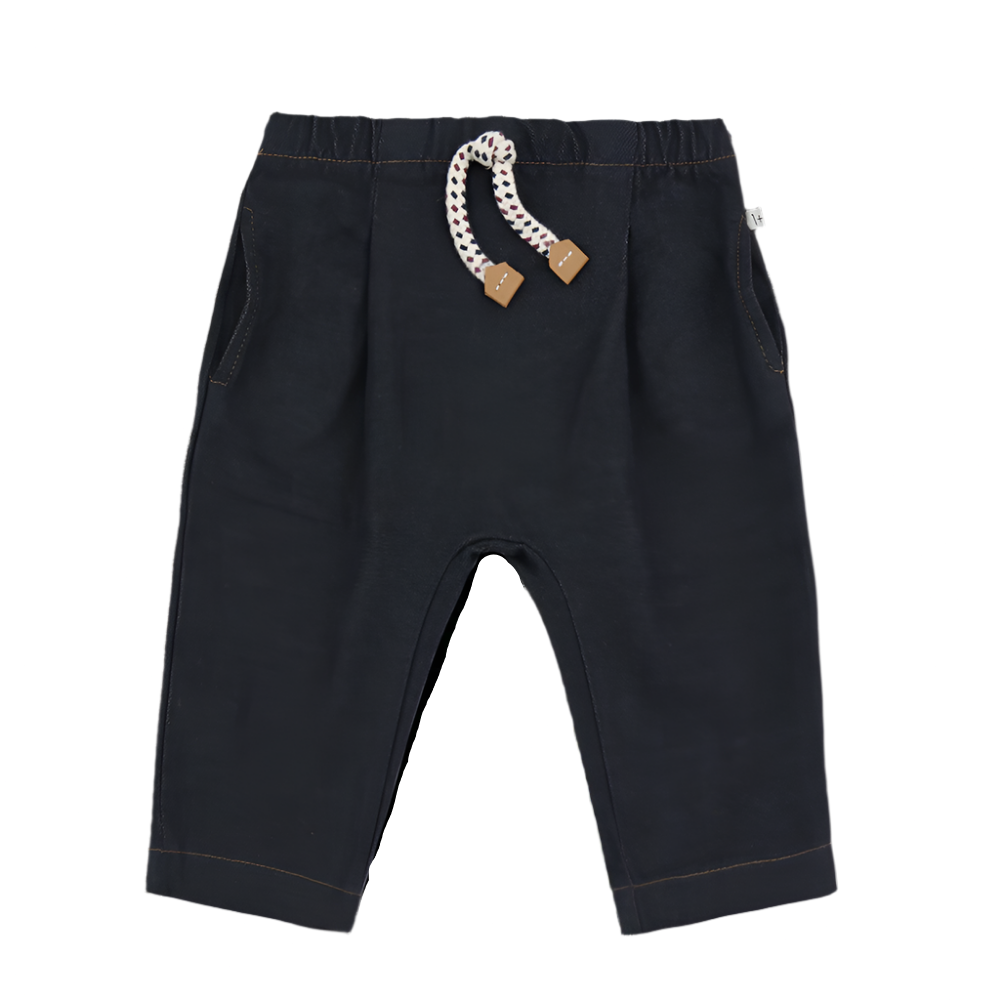 Black pants with a decorative pull cord on a white background
