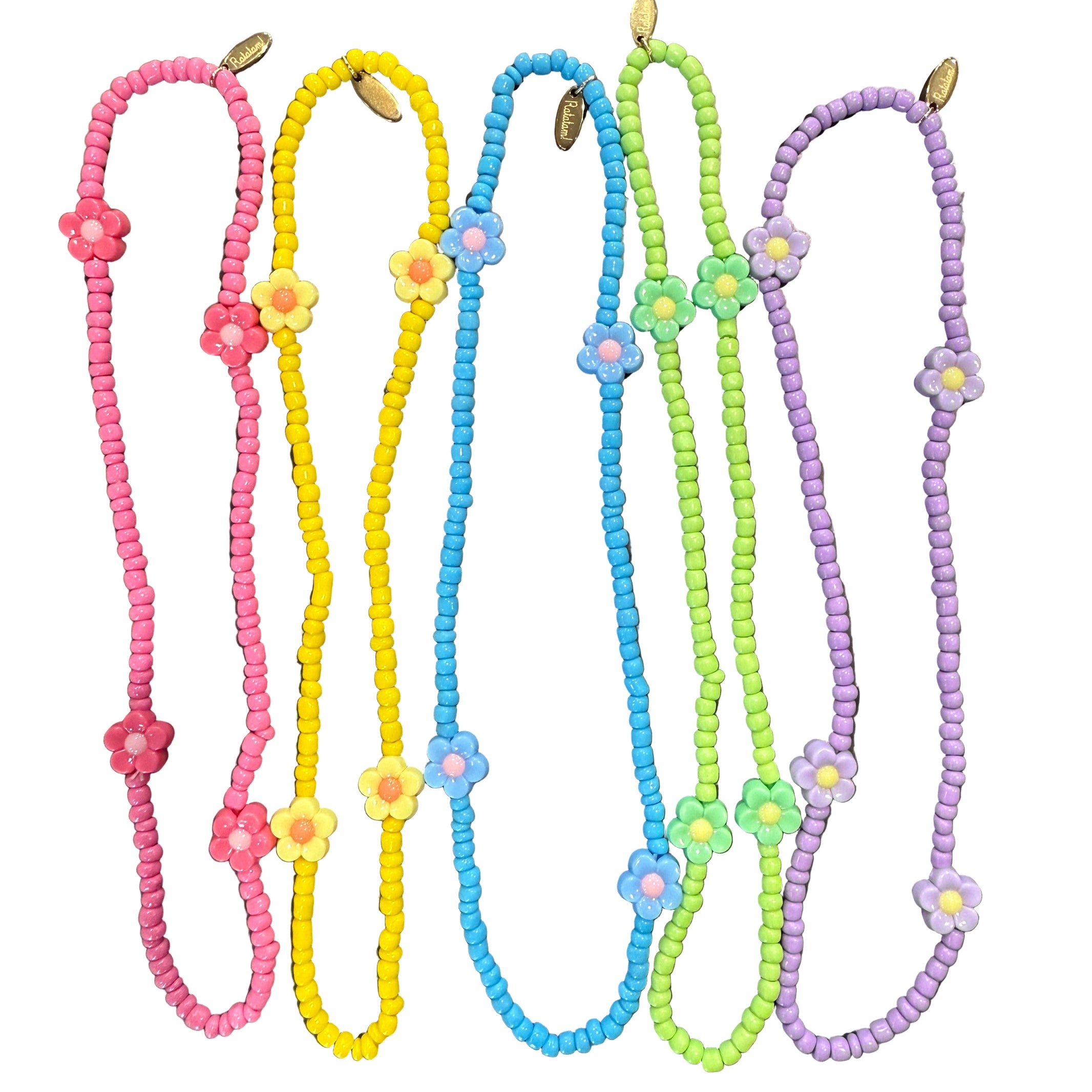 Colorful beaded necklaces with floral ends on a metallic surface - Little-ish