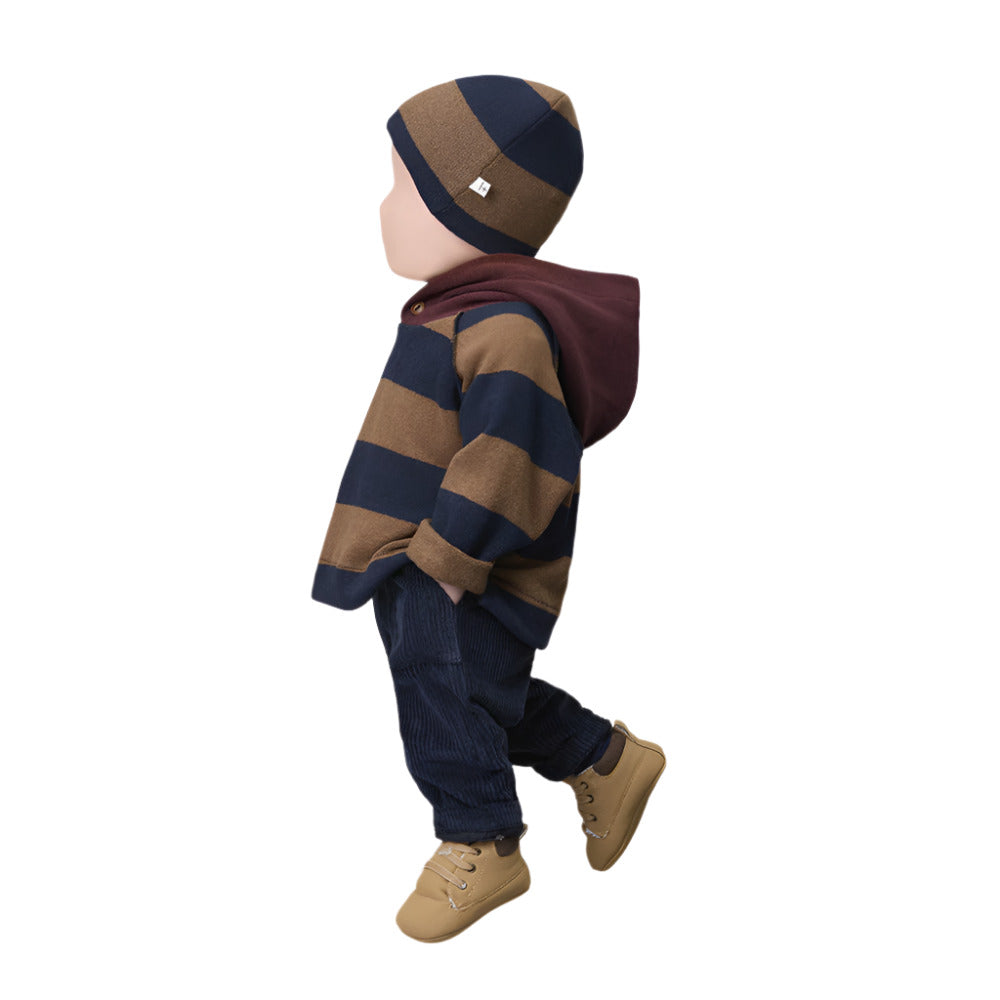 Child wearing a striped hoodie, pants, and hat on a white background