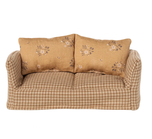 Beige sofa with floral-patterned cushions on a white background