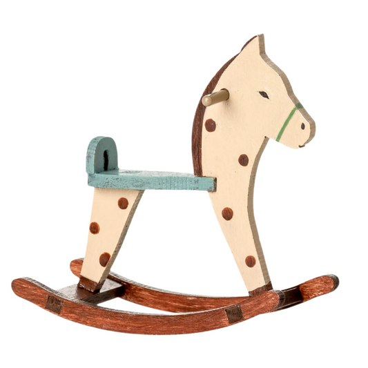 Wooden rocking horse with polka dot design on a light beige background