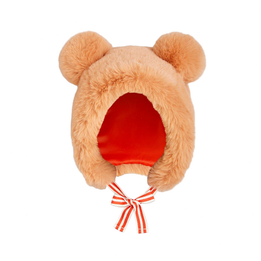 Furry peach-colored hat with red interior and white ribbon on a white background