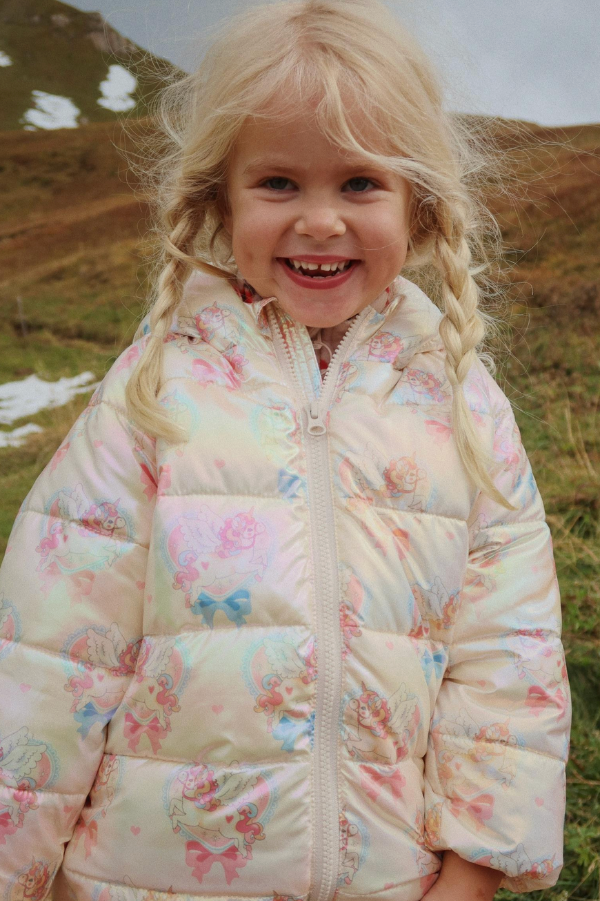 Child wearing a floral-patterned jacket in a natural setting