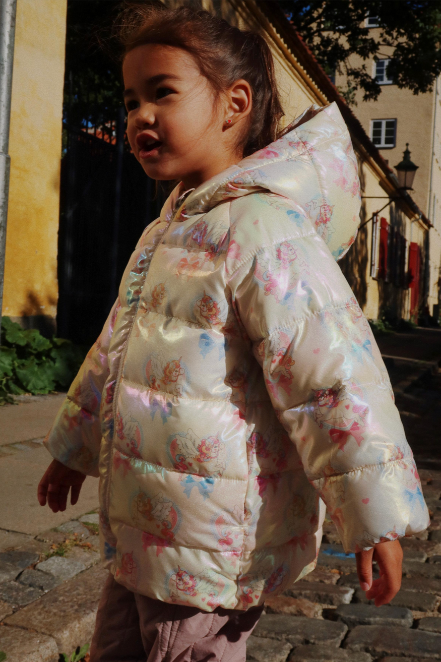 Child wearing a floral-patterned puffer jacket on a street.