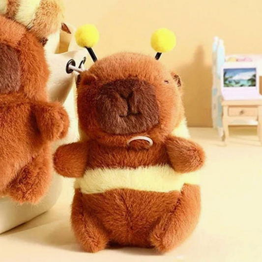 Plush toy resembling a beaver with yellow balls on its head, sitting on a light-colored surface.