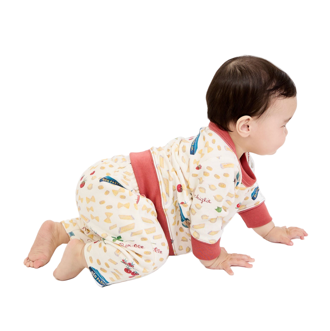 Baby in a patterned outfit crawling on a white background