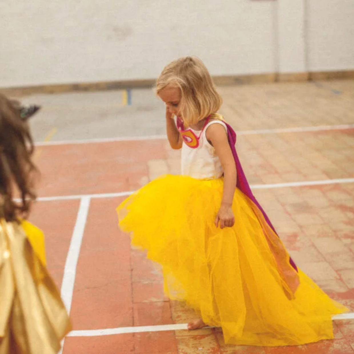 Two children in colorful costumes on a basketball court - Little-ish