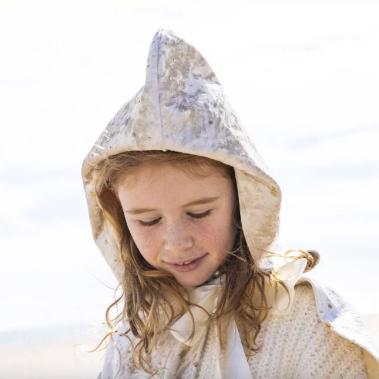 Child wearing a hooded garment with a white background