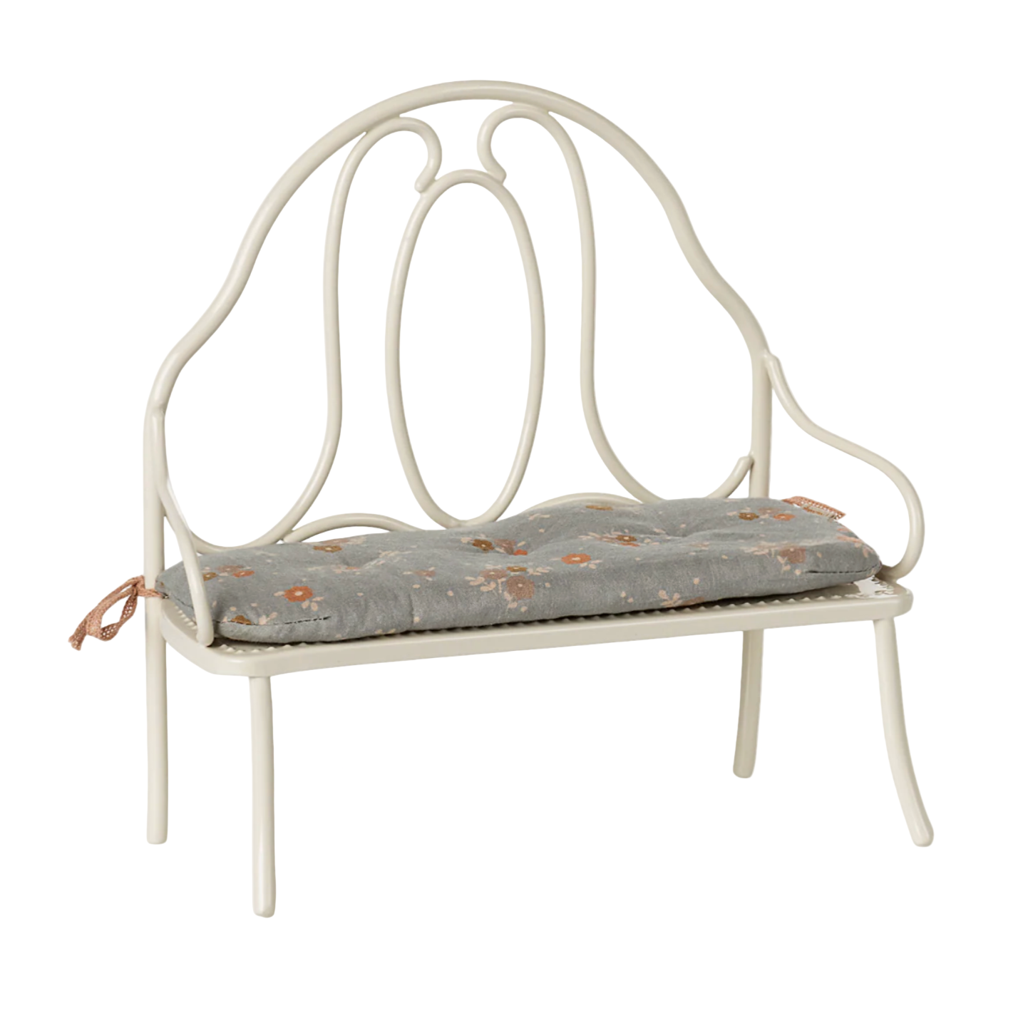 White metal bench with a floral cushion on a light beige background — Little-ish