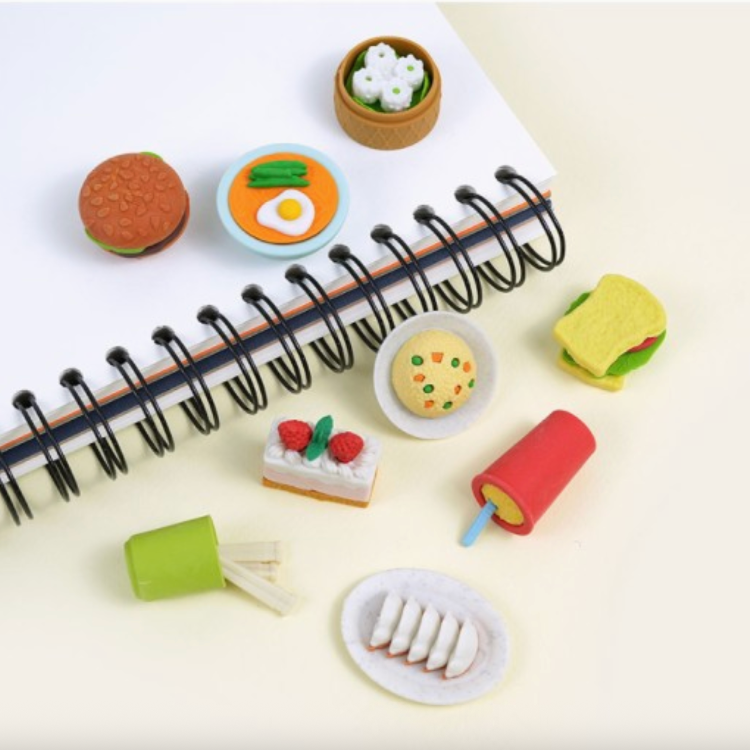 Miniature food items arranged around a notebook on a light background - Little-ish