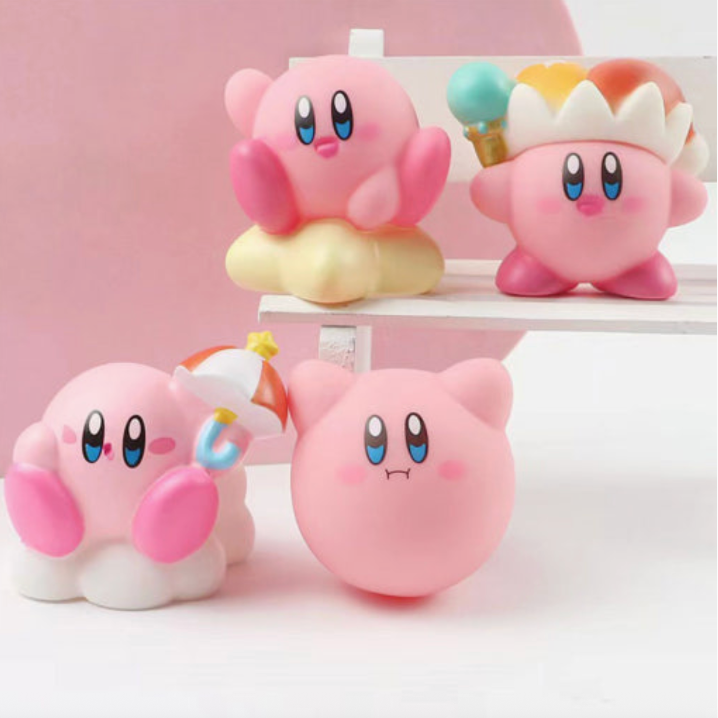 Four pink cartoon characters with blue eyes and colorful hats on a white shelf against a pink background - Little-ish