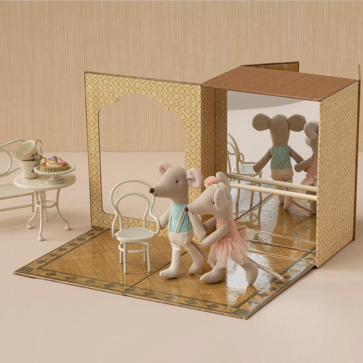 Toy mice in a miniature room with furniture and a mirror.
