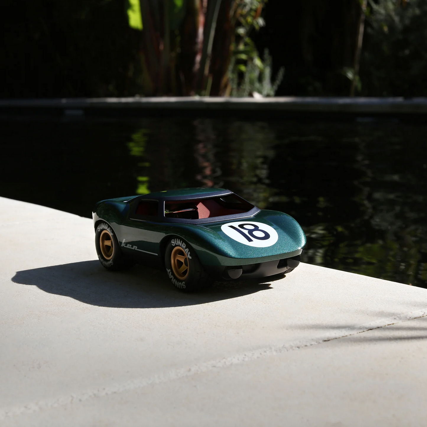 Model car with number 18 on a concrete surface near water