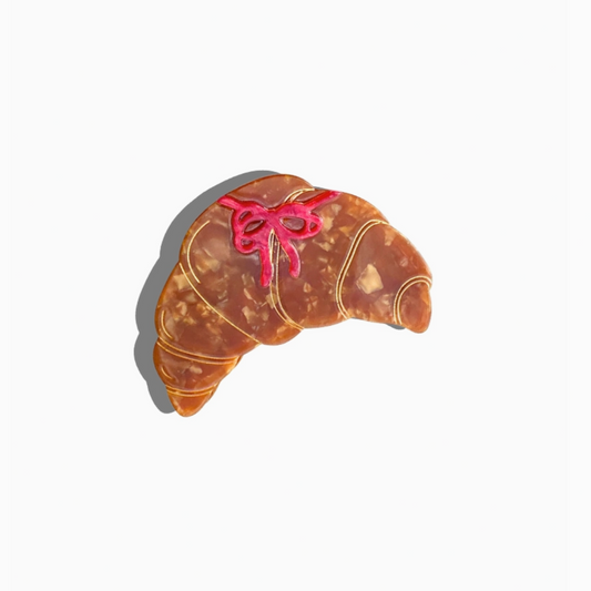 Croissant-shaped cookie with a pink bow on a white background