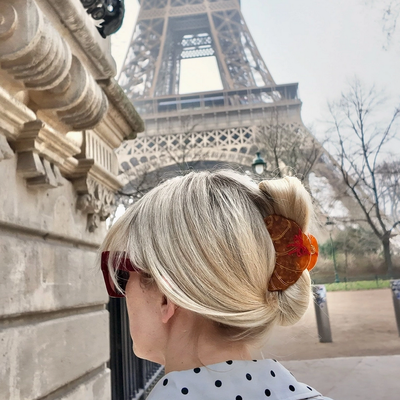 Person with styled hair in front of the Eiffel Tower