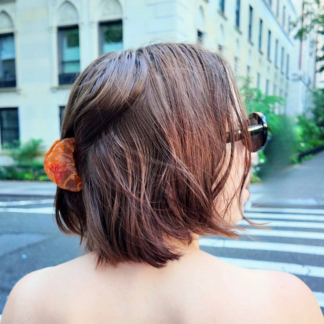 Person with a short haircut standing on a city street