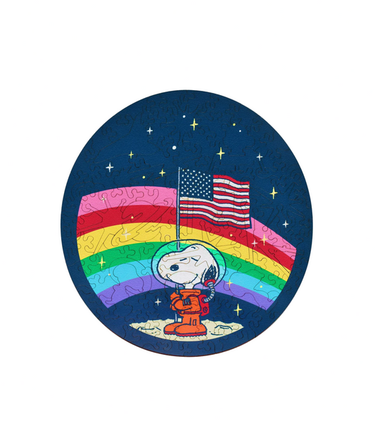 Circular sticker with Snoopy in astronaut suit on moon holding American flag and rainbow