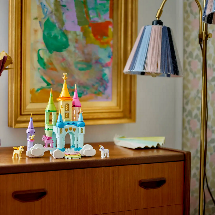 Wooden dresser with decorative items including a castle, vases, and figurines in a room setting.