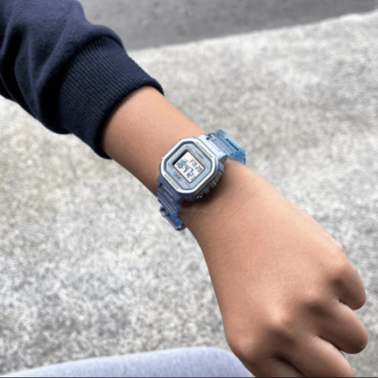 Digital watch on a wrist with a blurred background