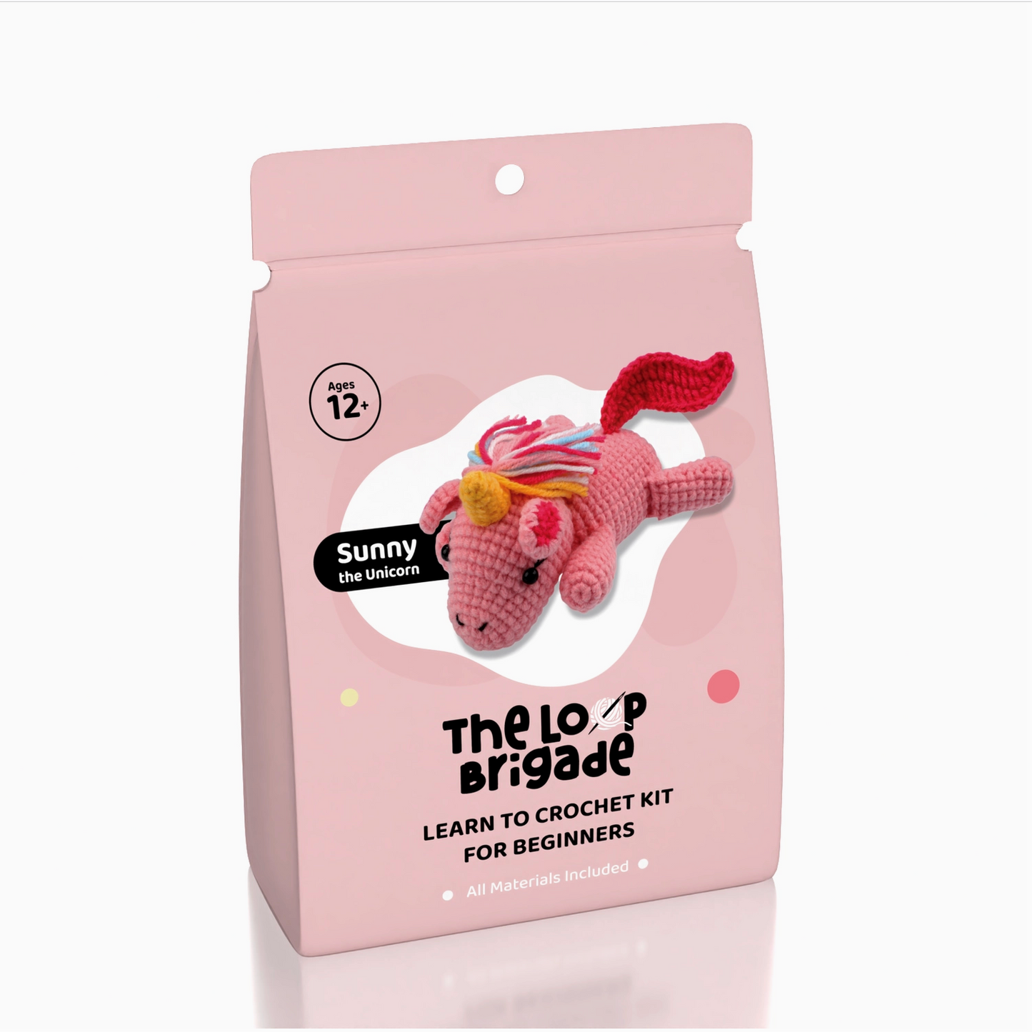 Crochet kit packaging with a pink unicorn toy on a white background