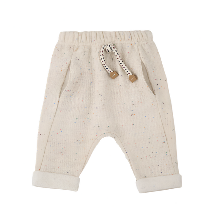 Beige baby pants with a rattle on a white background