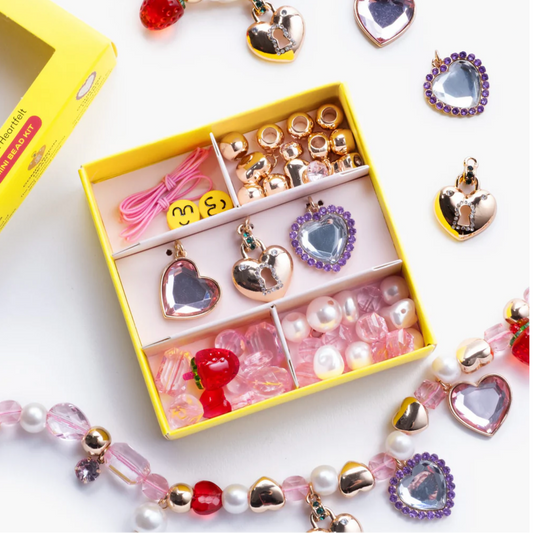 Children's jewelry set with heart-shaped charms and beads in a yellow box on a white background
