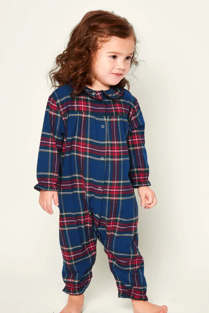 Child wearing a blue and red plaid onesie against a white background
