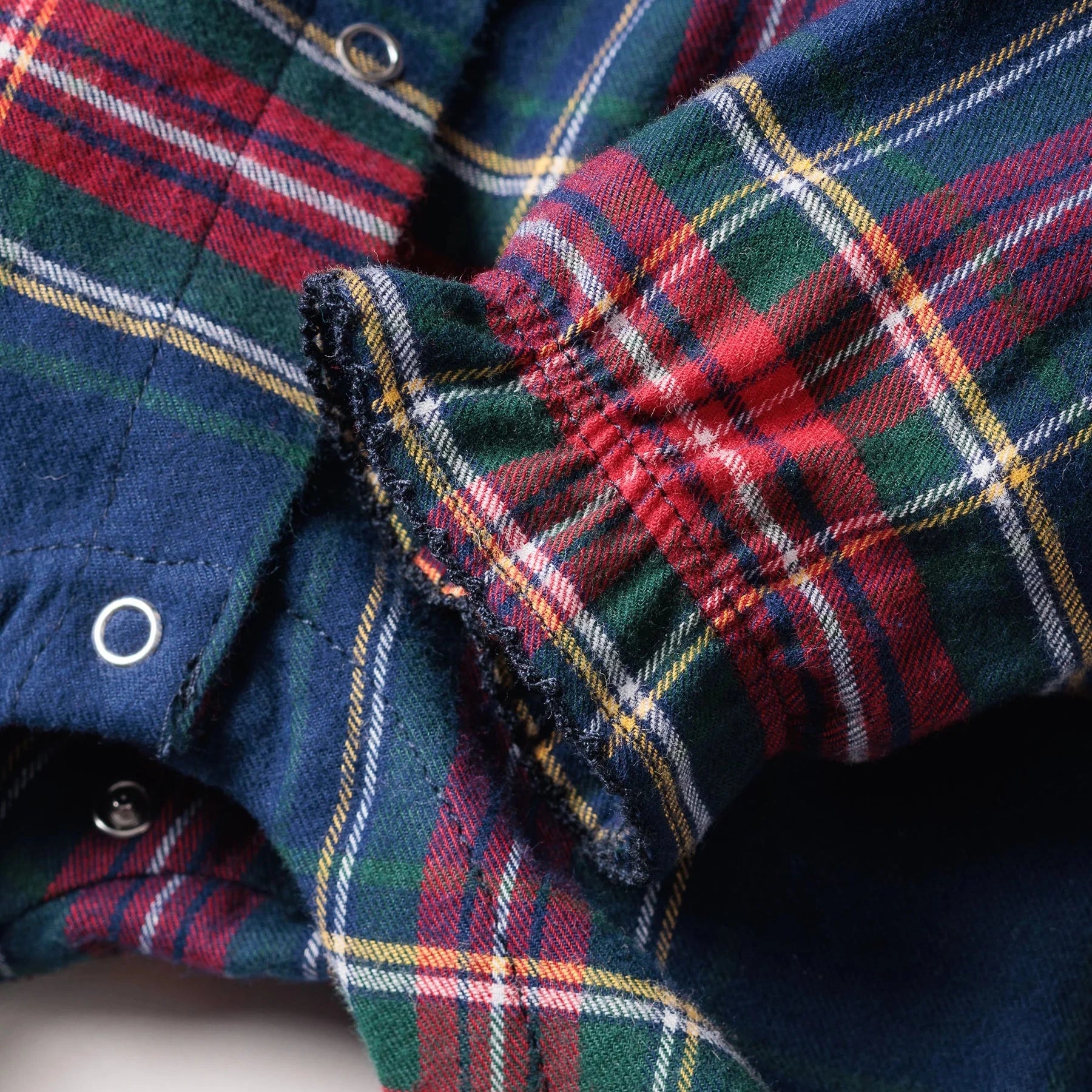 Close-up of a plaid fabric with red, green, and blue colors.
